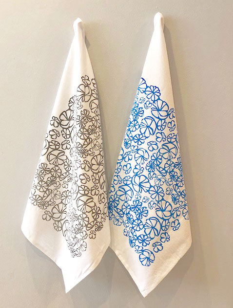 an image of one grey and one blue hanging kitchen towel decorated with  an abstract floral design